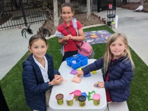 Three girls enjoy arts and crafts at summer camp.
